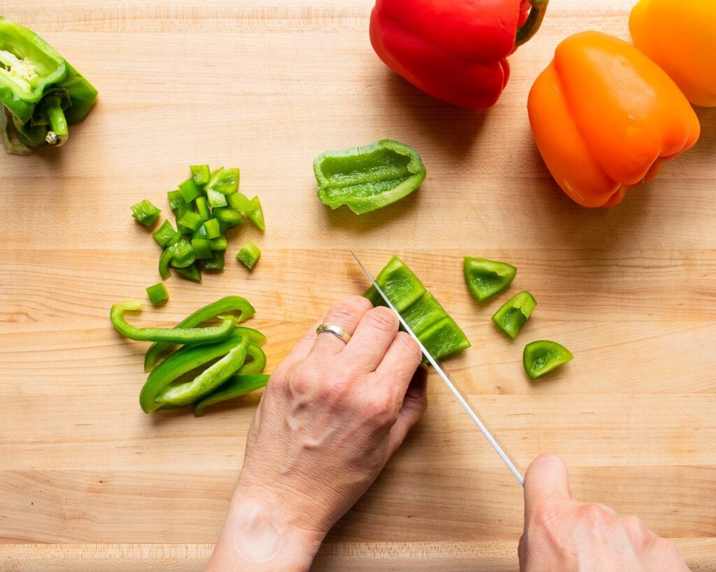 A green pepper cut into different cuts.