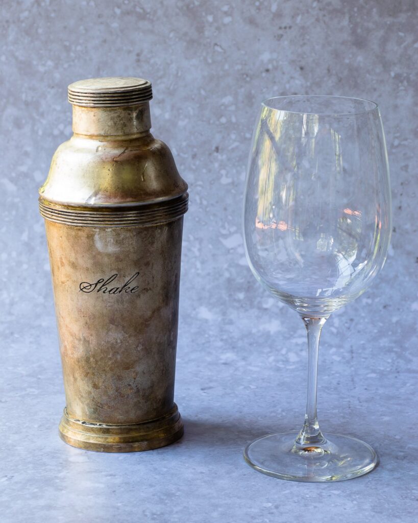 A cocktail shaker and a wine glass.