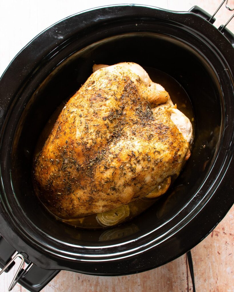 Cooked roast turkey breast in a slow cooker.