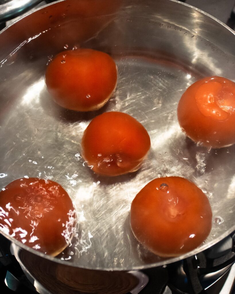 Tomatoes blanching in a stockpot.