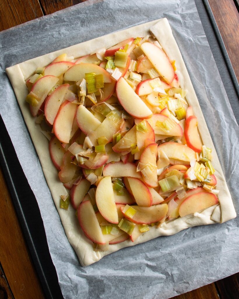 Apples and leeks on puff pastry - a step in making apple leek cheddar tart.