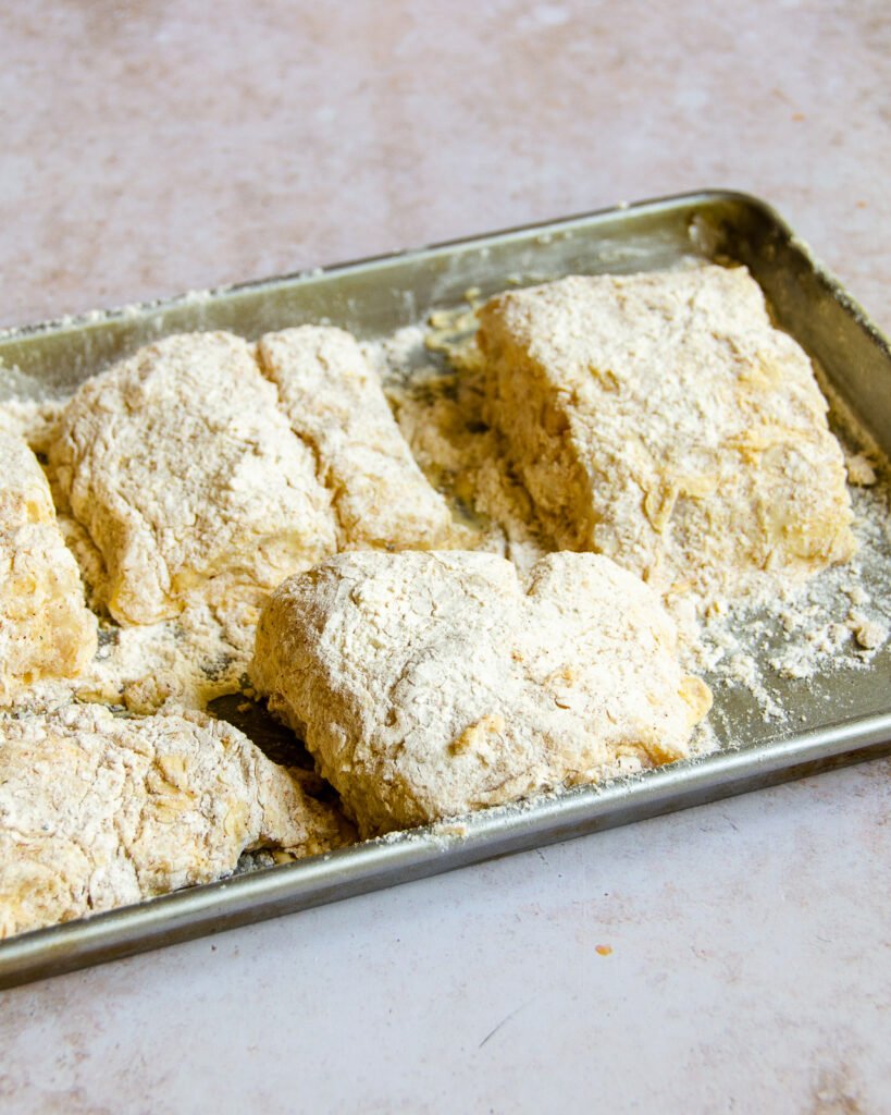 Cod fillets, dredged and on a baking sheet.