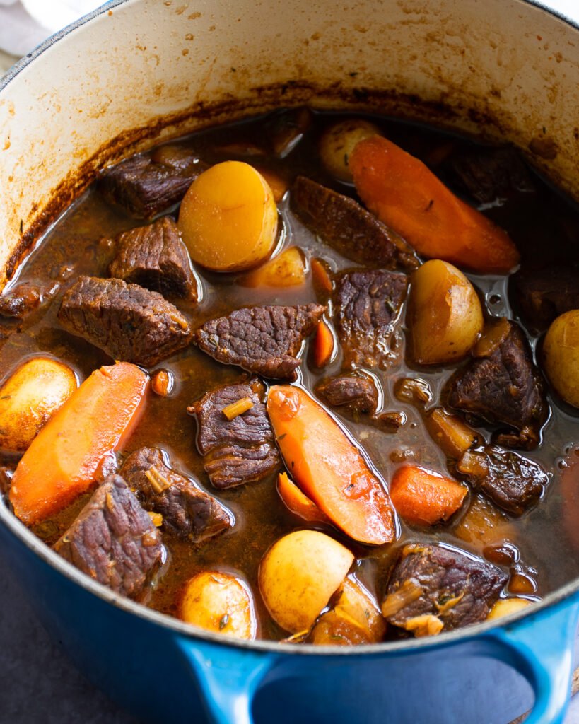 Guinness beef stew in a blue cast iron Dutch oven after simmering for 2 hours.