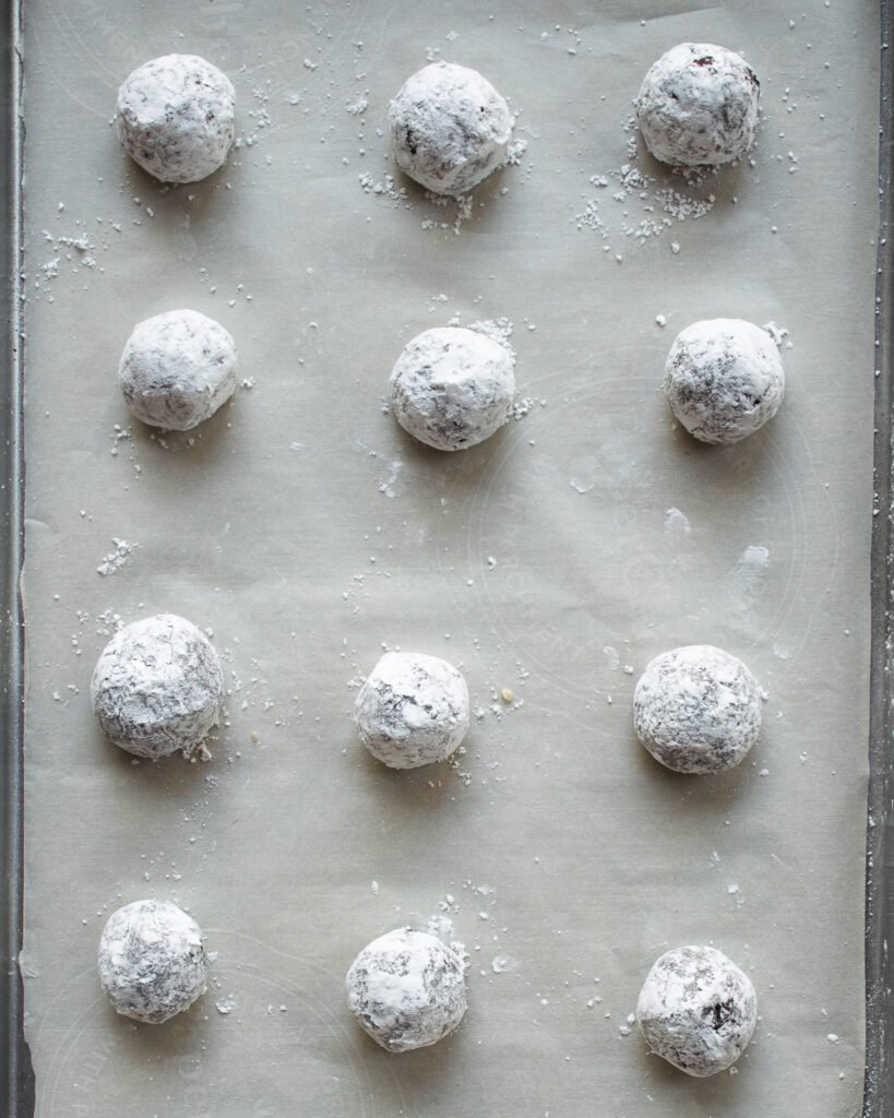 Unbaked cookies on a parchment lined baking sheet.
