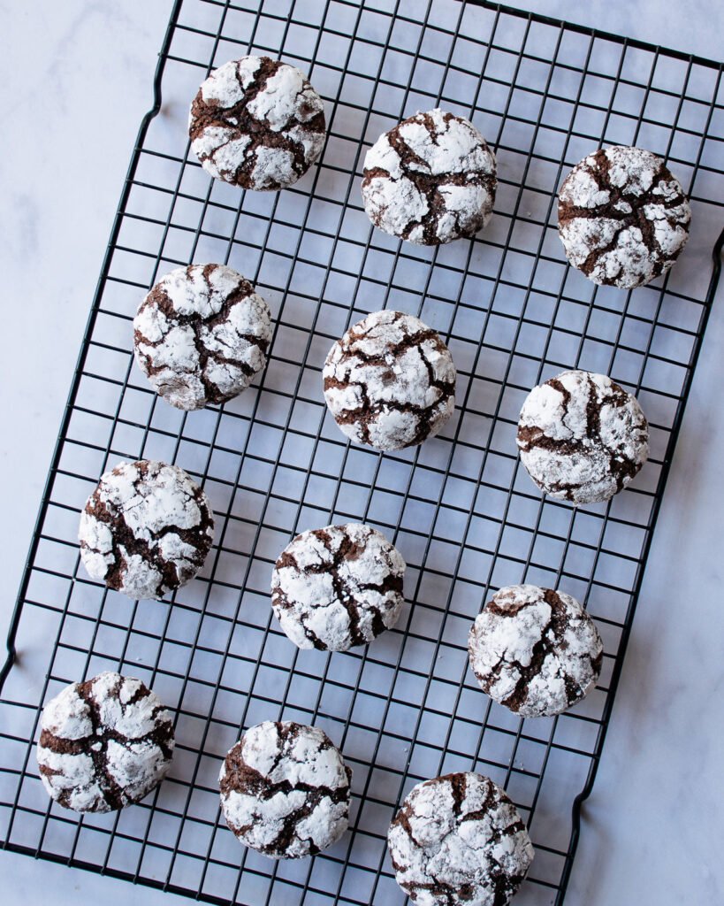 Chocolate Crinkle Cookies cooling on a cooling rack.