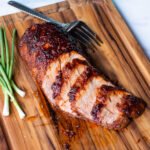 Pork loin sliced on a cutting board.