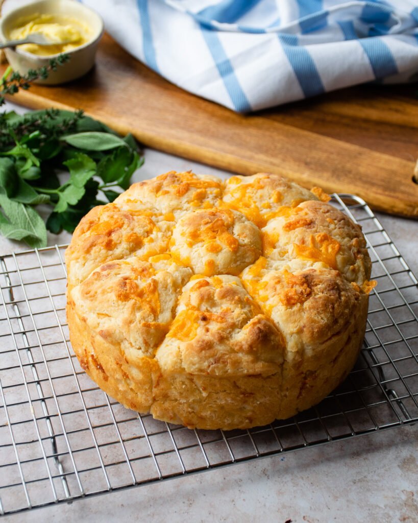 Cheddar cheese biscuits cooling on a cooling rack.