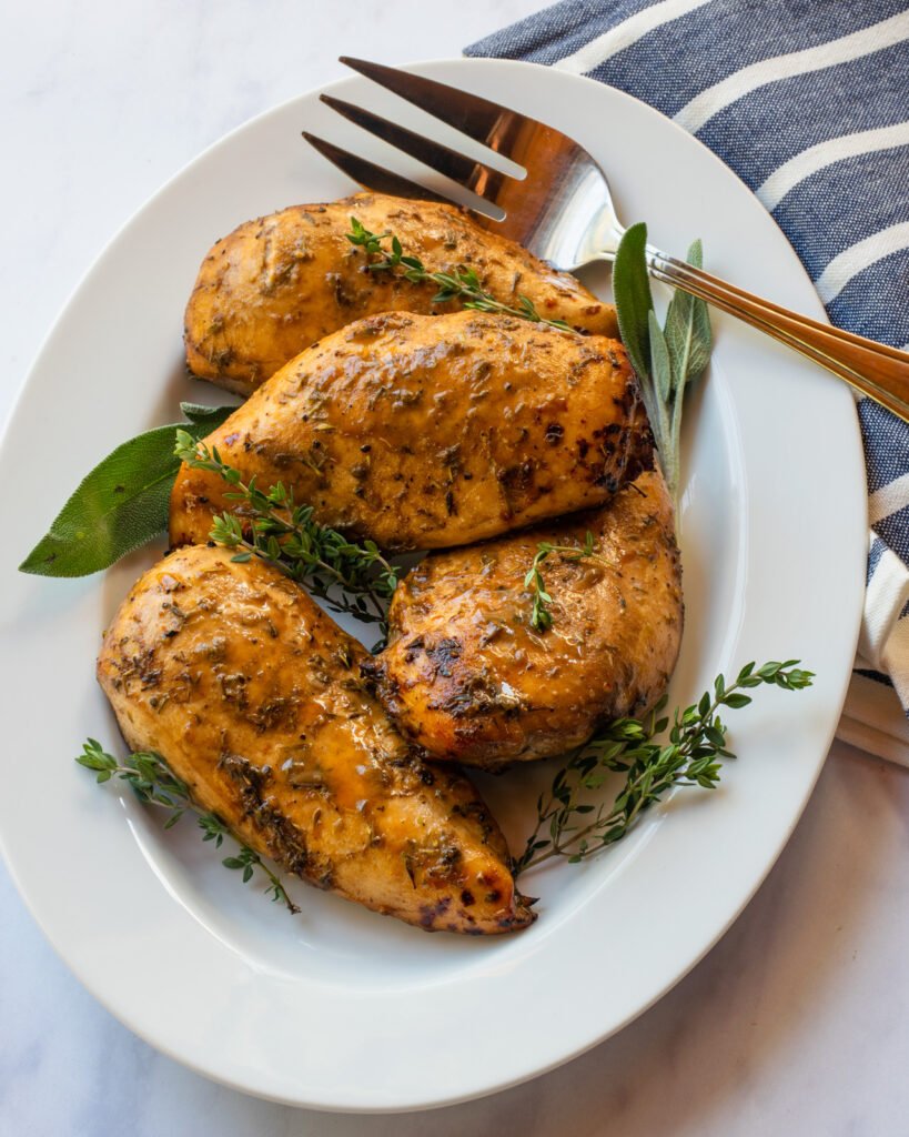 Air fried chicken breasts on a white plate with a serving fork.