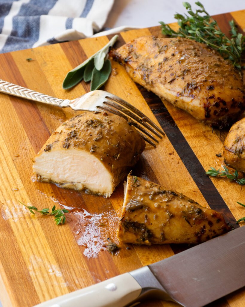 Chicken breast sliced open on a cutting board.