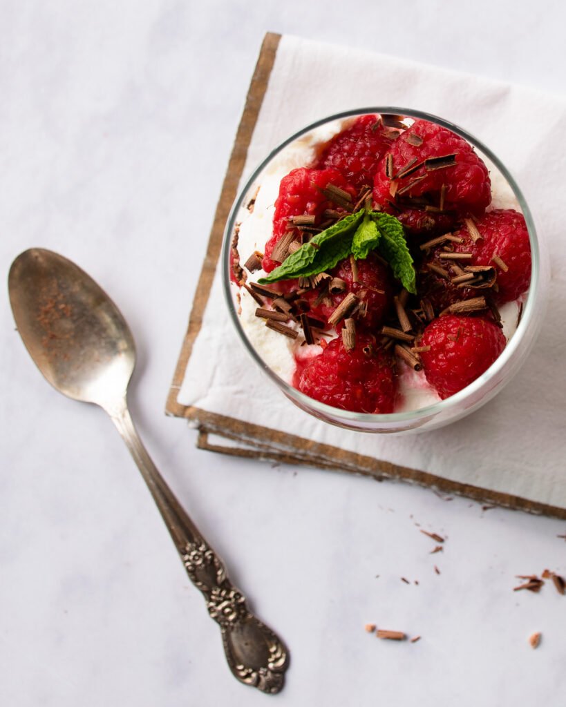 Looking straight down into a stemless wine glass filled with chocolate eton mess.