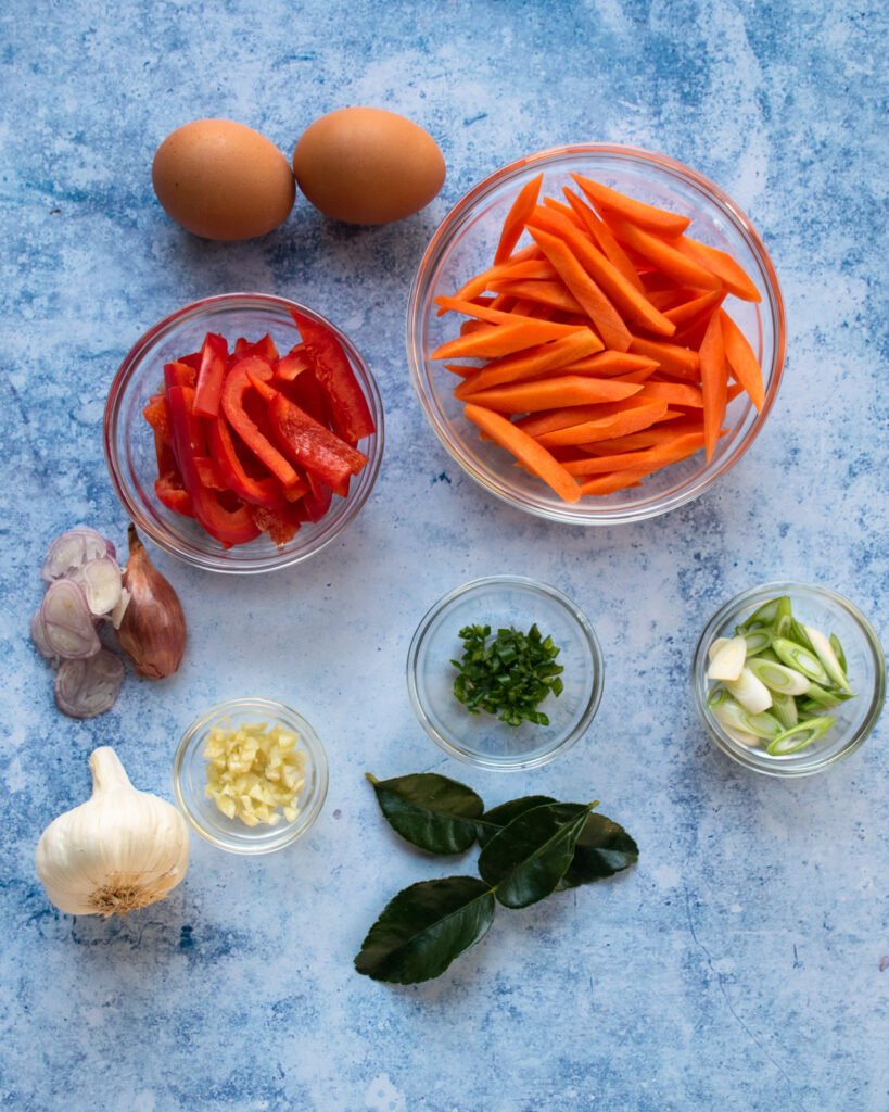 Ingredients for drunken noodles - carrots, red pepper, ginger, garlic, shallots, lime leaves, eggs and scallions.