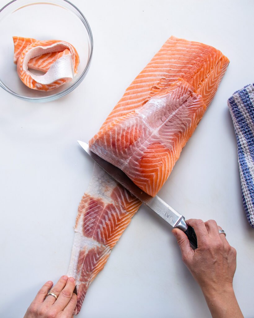 Showing how to remove skin from a side of salmon