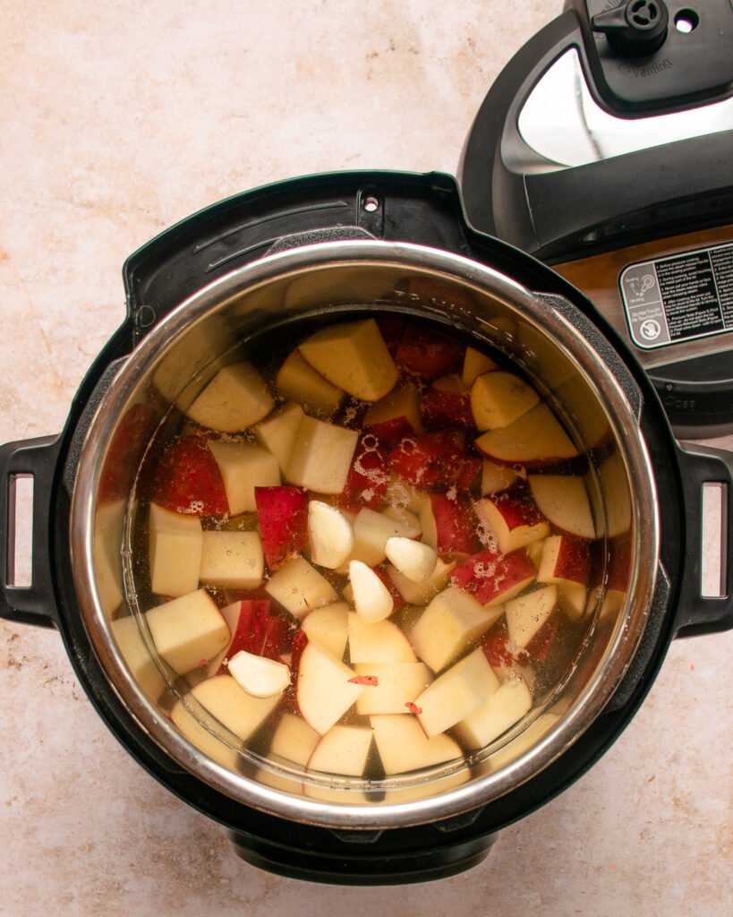 Red potato chunks in a pressure cooker.