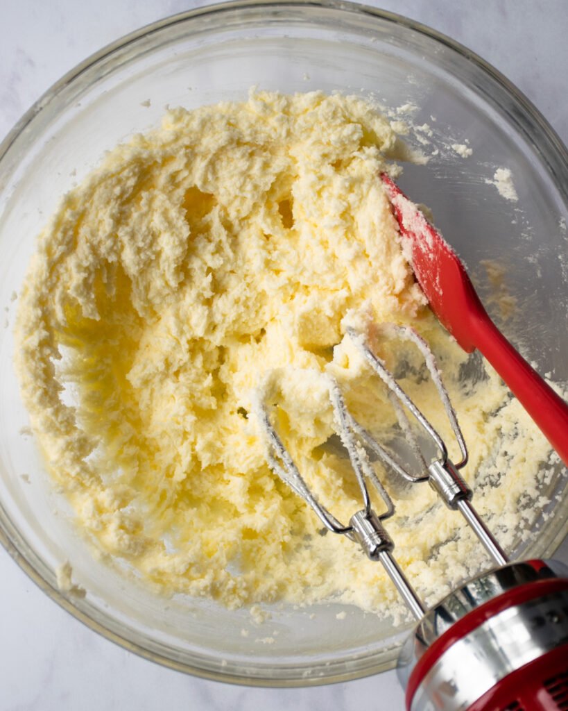 Butter and sugar over-mixed in a bowl.