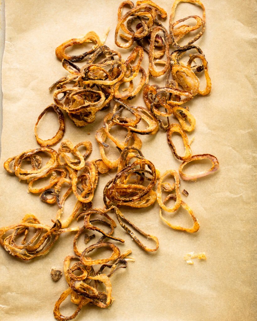 Crispy shallots on parchment paper.