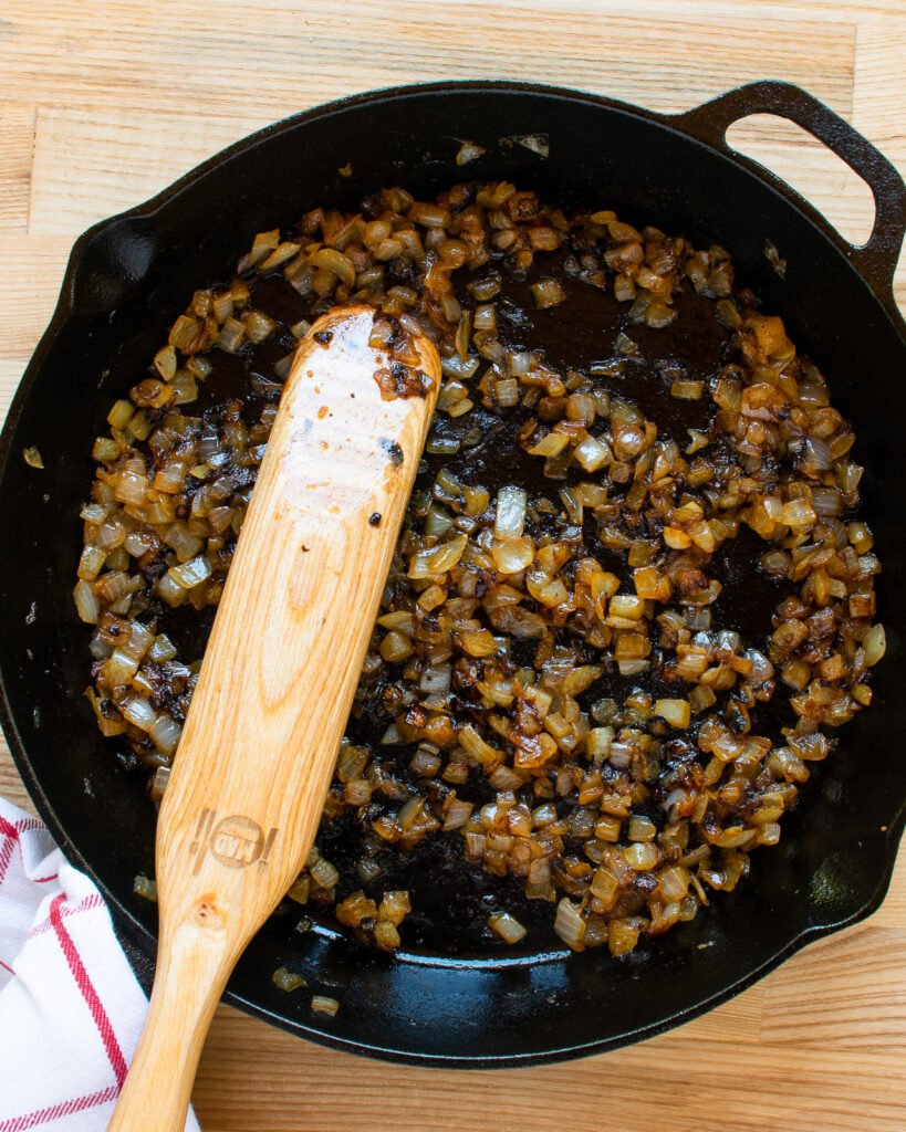 Onions cooking in a cast iron skillet.