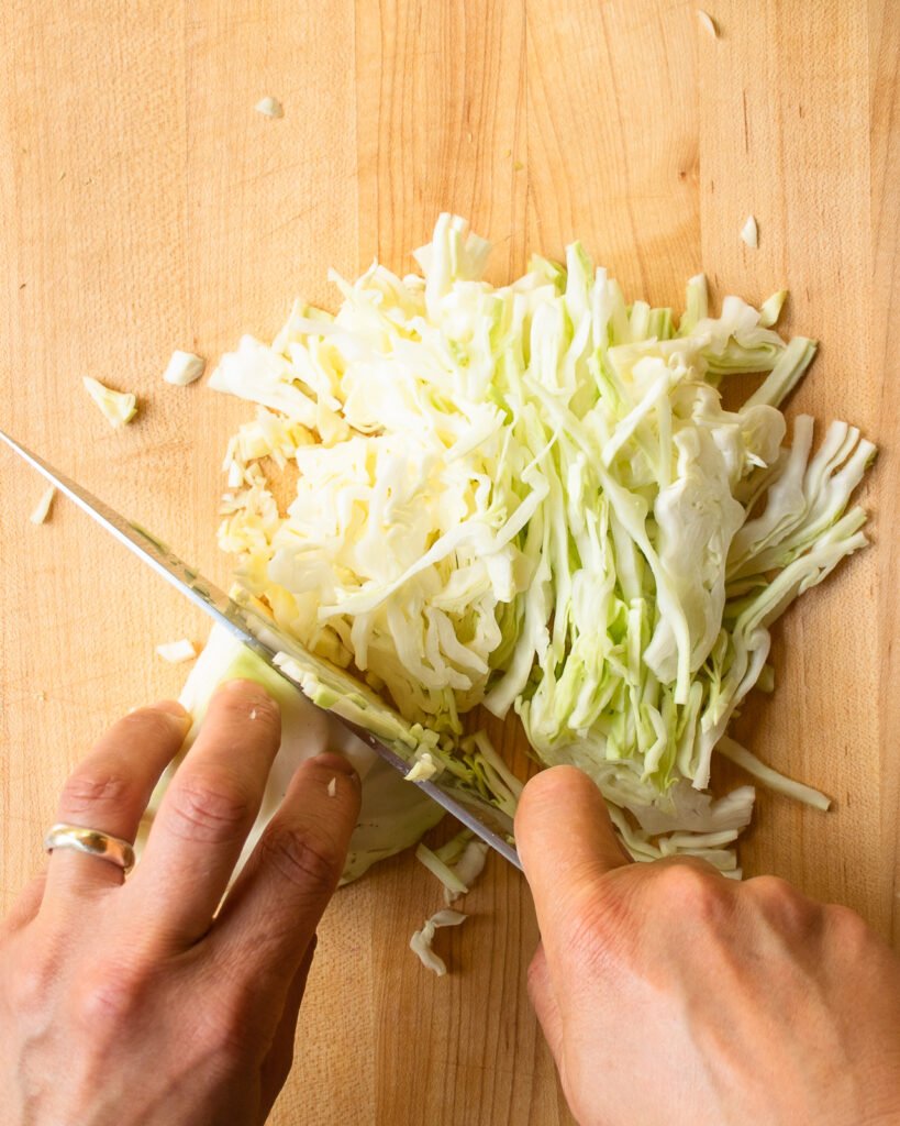 Shredding cabbage with a chef's knife.