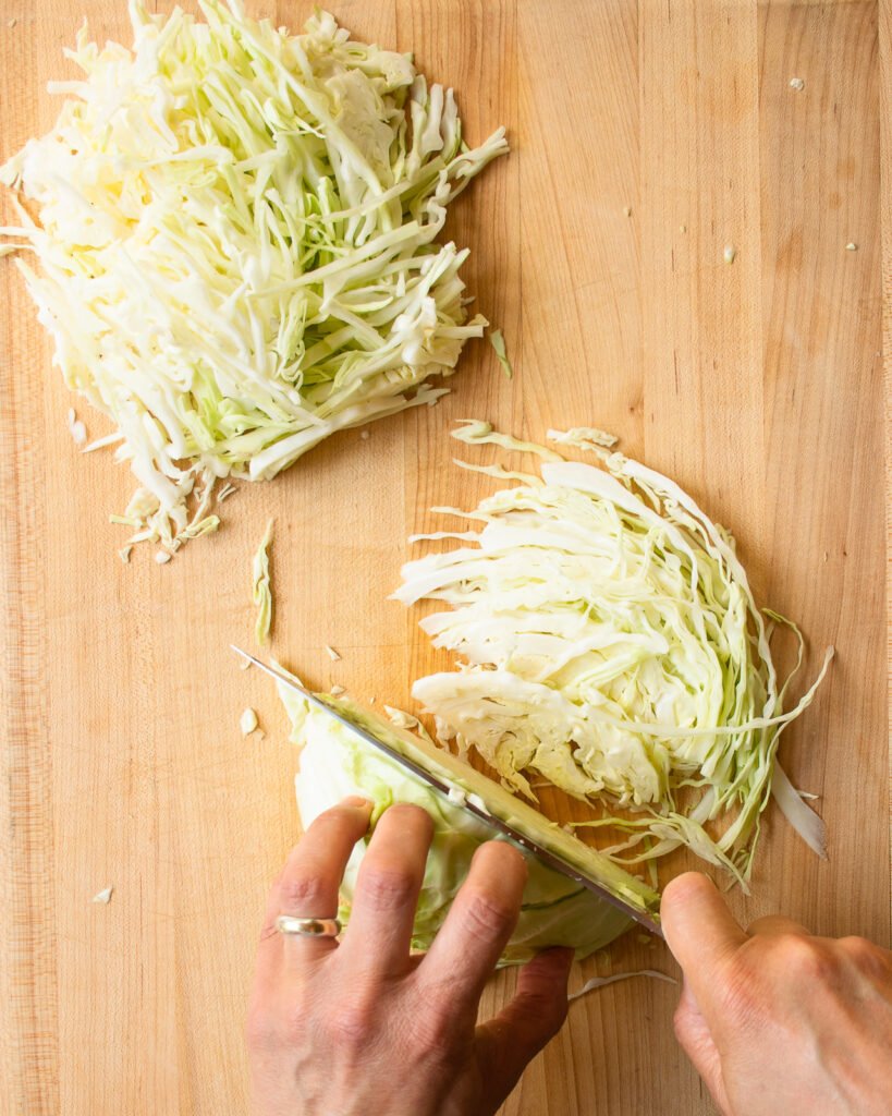 Shredding cabbage into long strips.