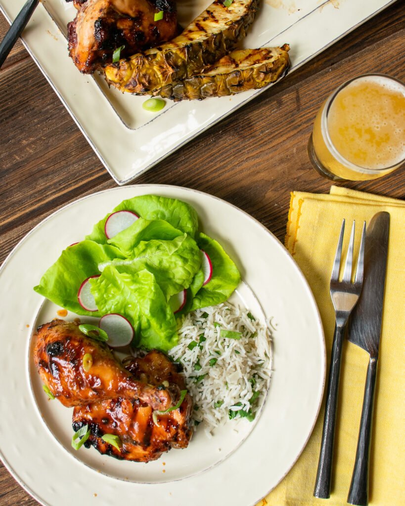 Huli Huli Chicken on white plate with greens and rice.