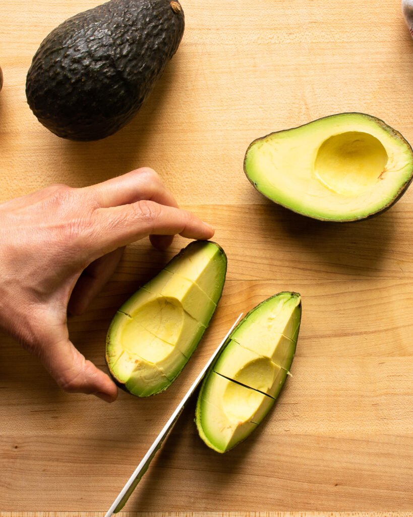 Cutting half an avocado in half again - showing how to cut an avocado.