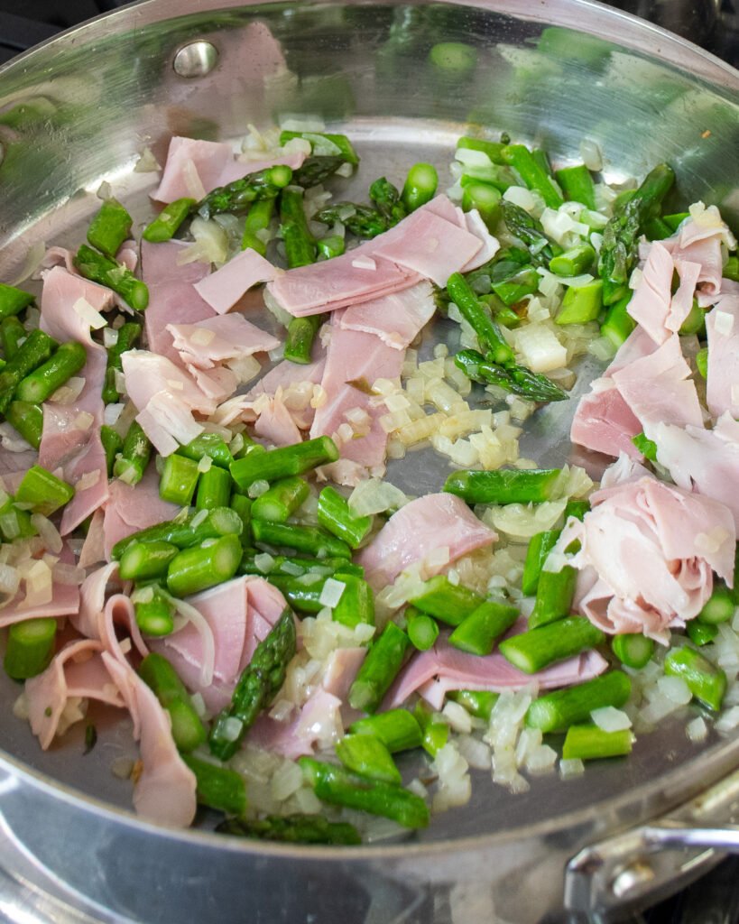 Ham, onion and asparagus in a large sauté pan.