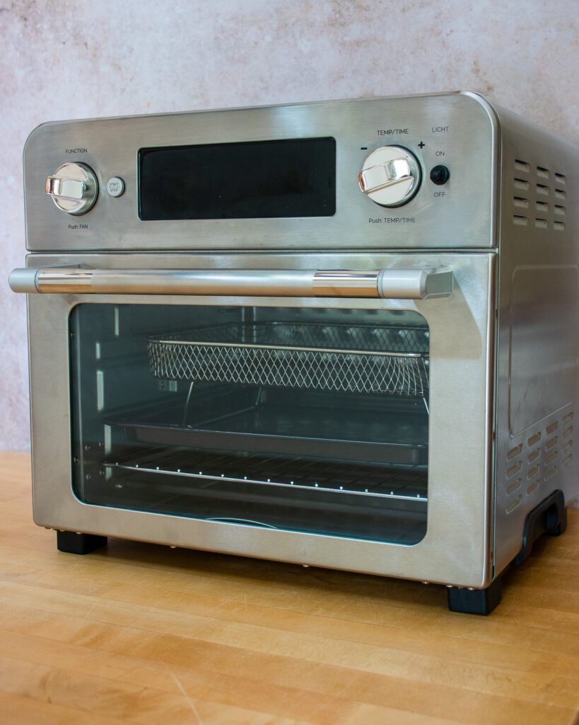 An air fryer oven sitting on a butcher block countertop.