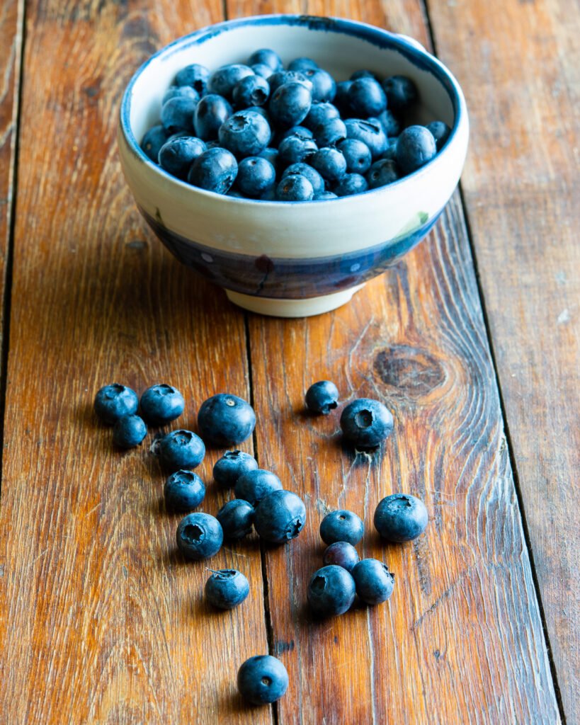 Blueberries in a bowl on a wooden table.