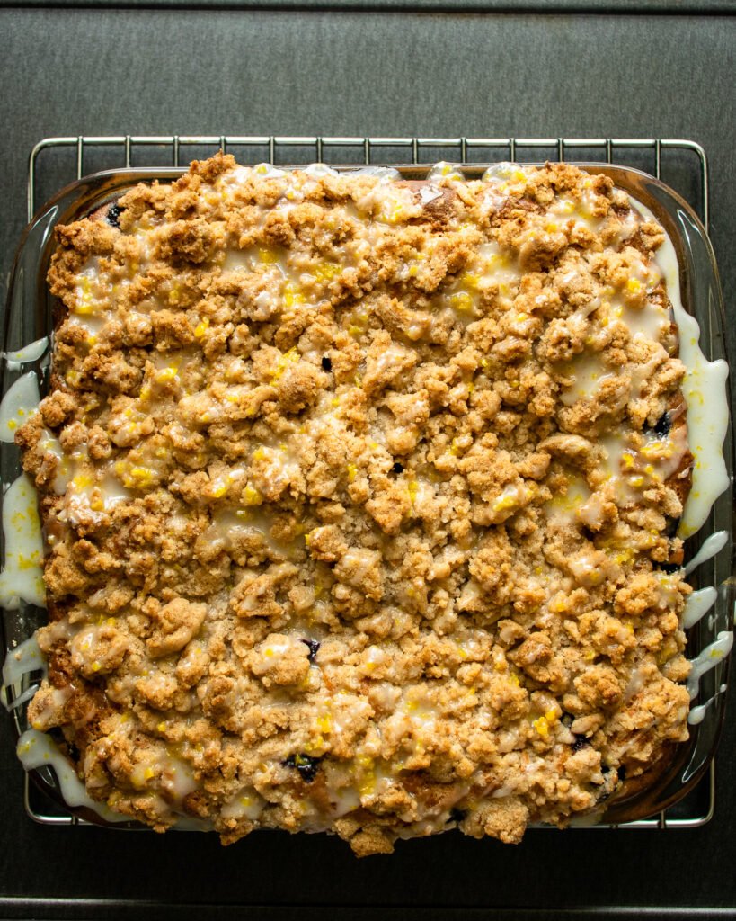 Looking straight down on blueberry crumb coffee cake with lemon glaze drizzled on top.