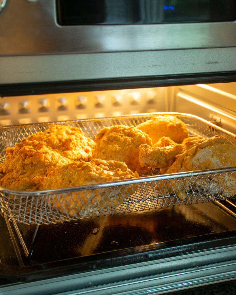 Air fryer fried chicken cooking inside an air fryer oven.
