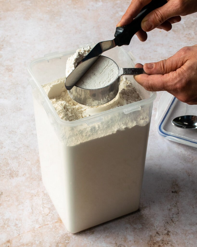 Leveling off a dry cup measure with an offset spatula.