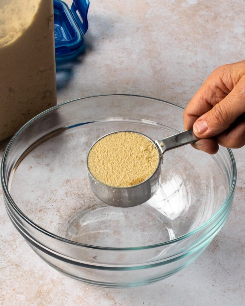 A dry cup measure with brown sugar packed into it.