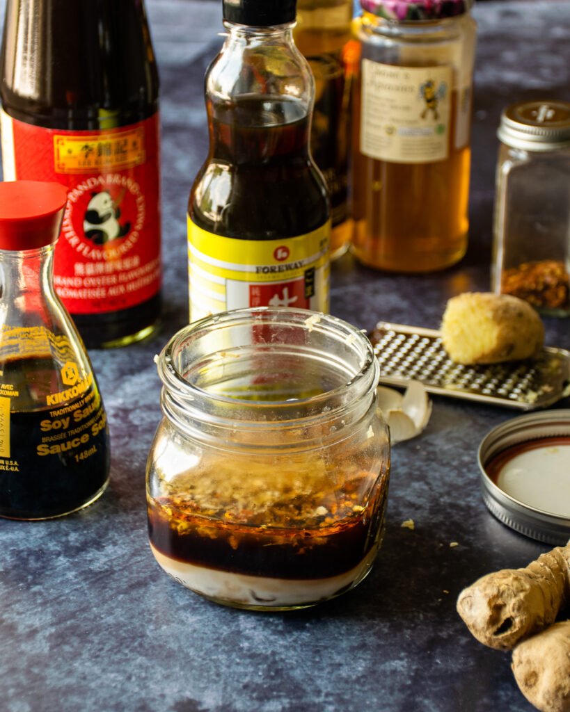 Ingredients surrounding a jar of unmixed stir fry sauce.