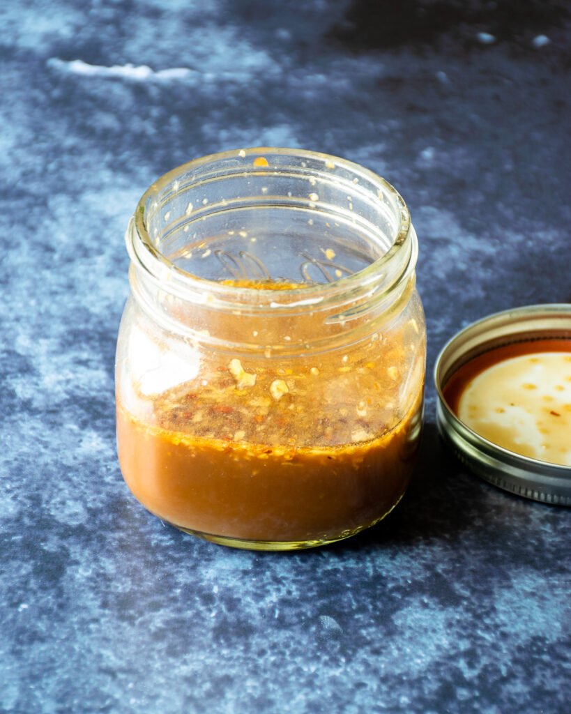 An open jar of stir fry sauce on a countertop.