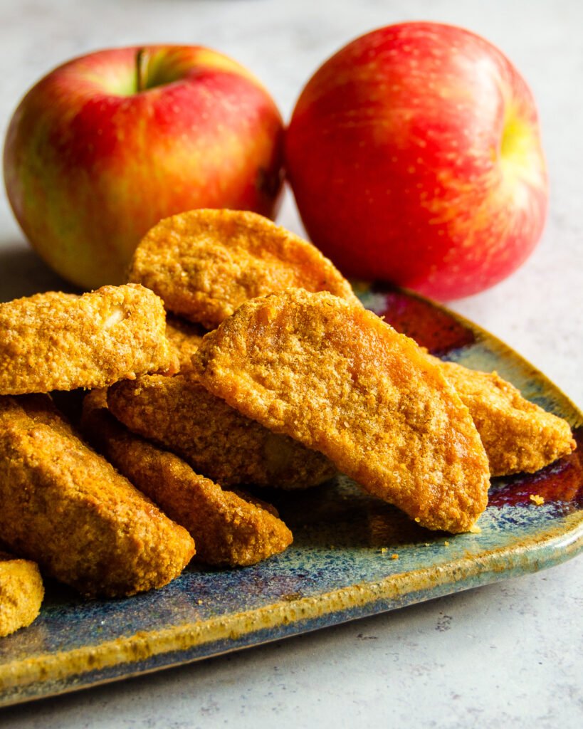 Close up of apple fries with two apples behind it.