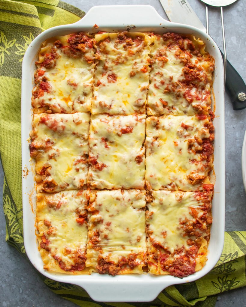 A casserole dish with lasagna, cut into 9 pieces.