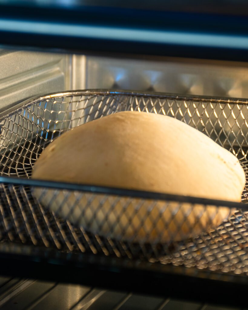 Pita bread cooking in an air fryer oven.