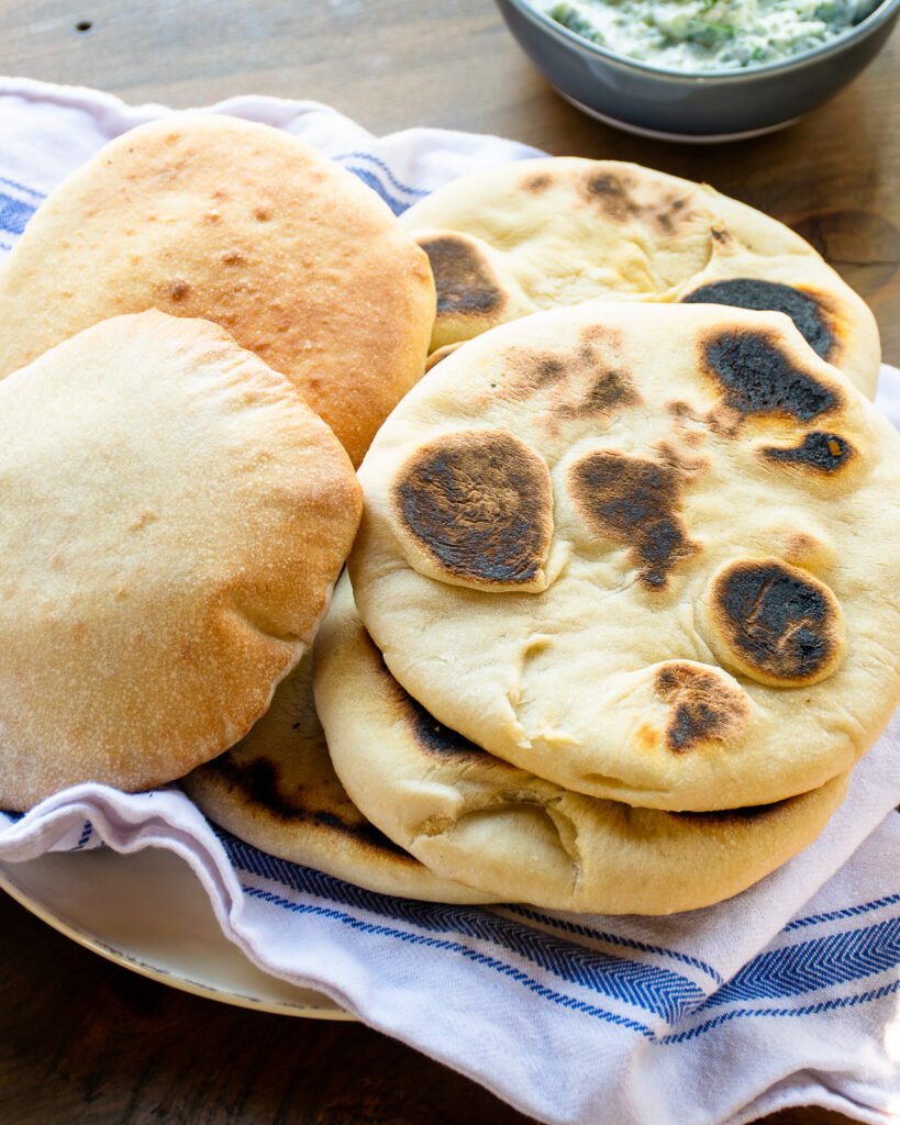Pita bread on a blue and white striped towel.