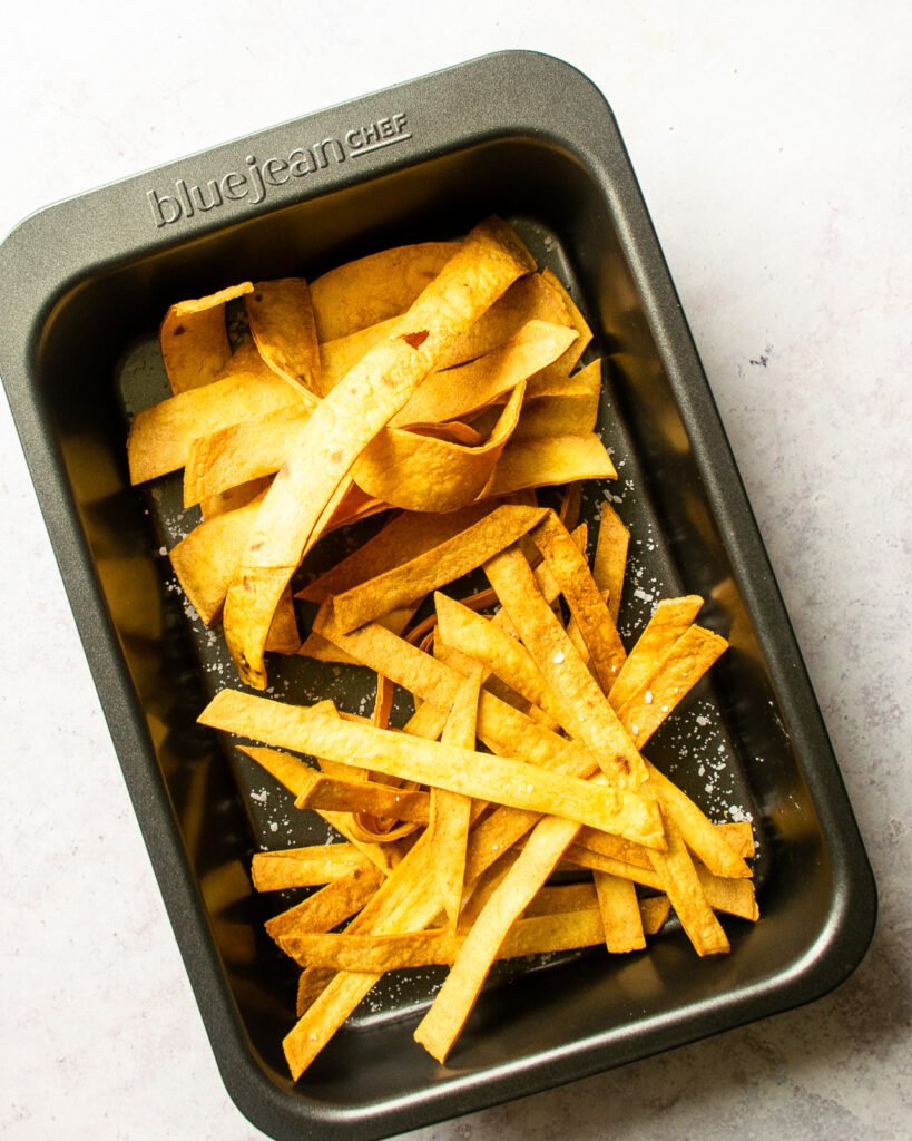 Tortilla strips and ribbons in a baking pan.