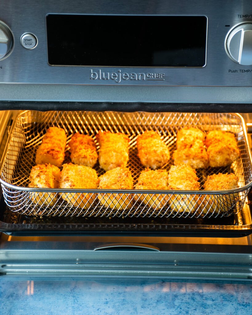Air fryer fish sticks cooking in an air fryer.