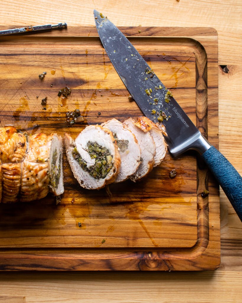 Slicing the turkey roulade on a cutting board.