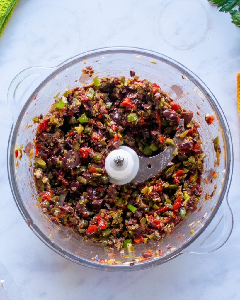 An olive salsa in a chopper.