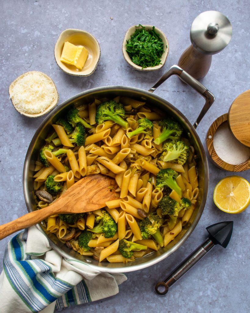 Looking down on one pot pasta with mushrooms before stirring in the seasonings.