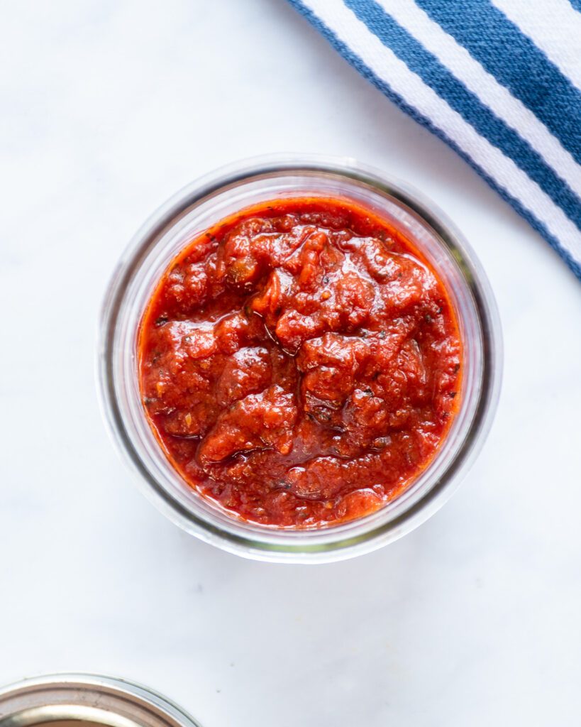 Looking into a jar of pizza sauce.