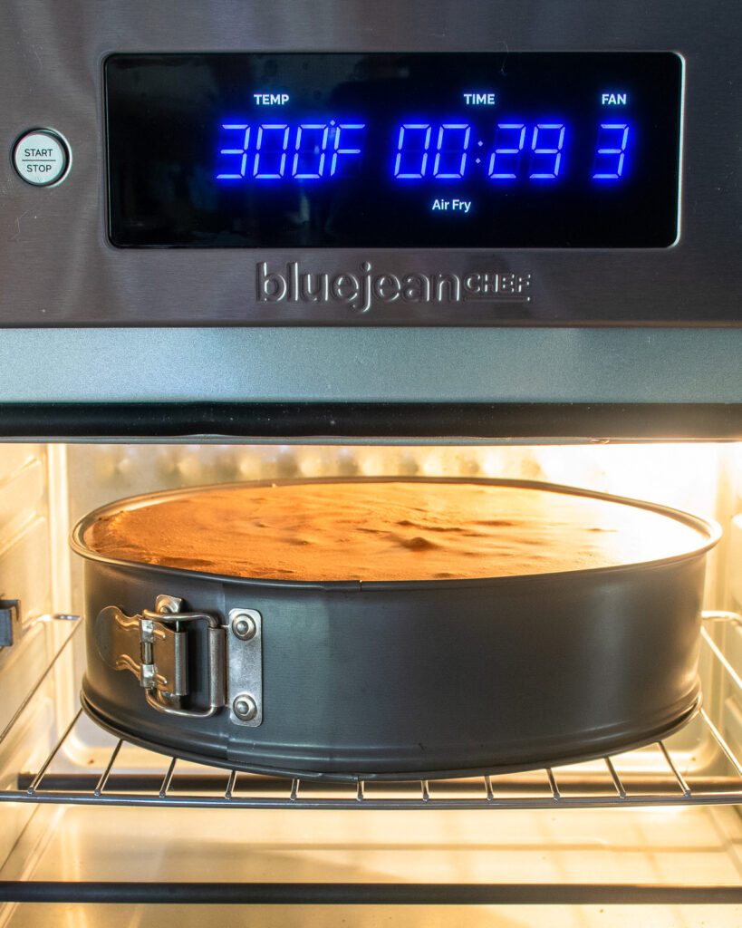 A cheesecake baking in an air fryer oven.