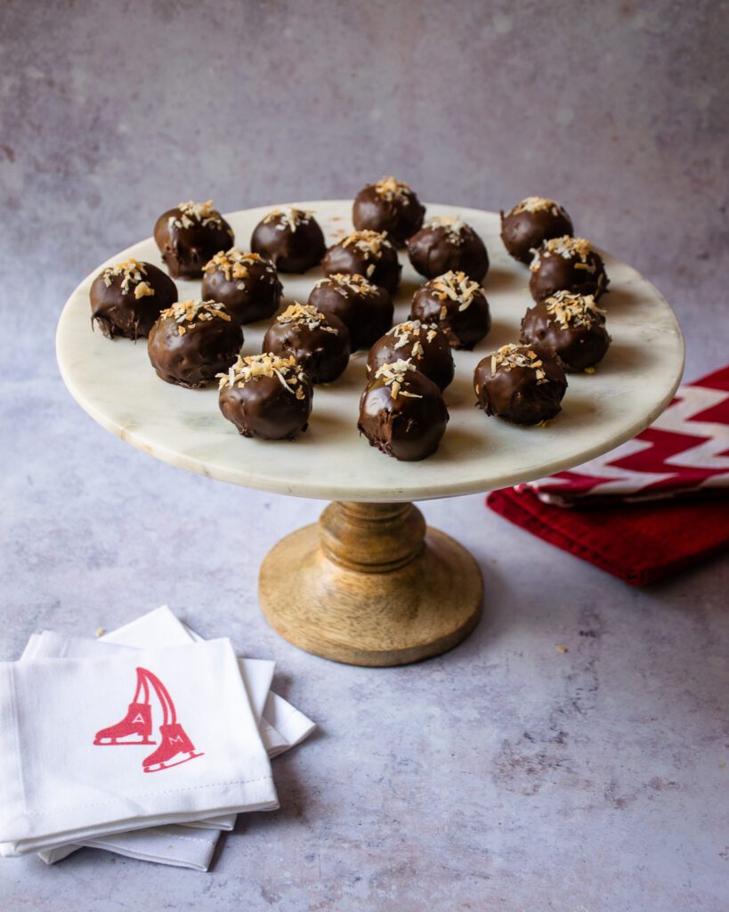Chocolate Toasted Coconut Balls on a cake stand with a few red and white napkins near by.