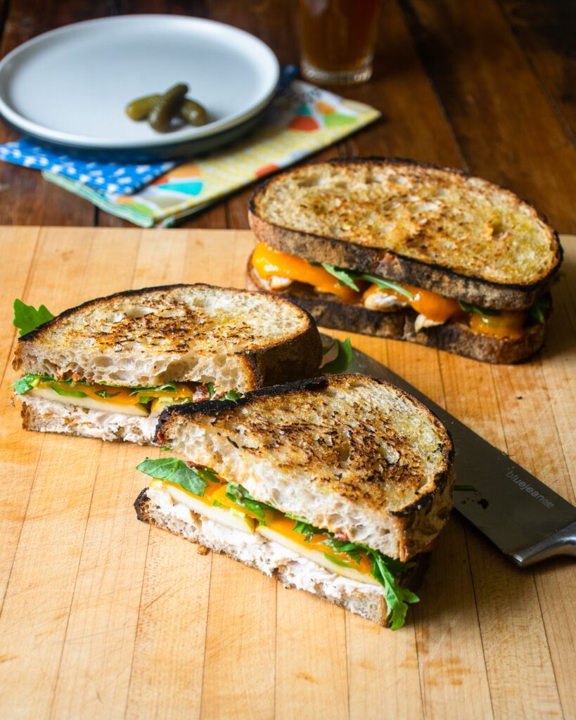 One spicy turkey panini cut open with a whole one in the background.