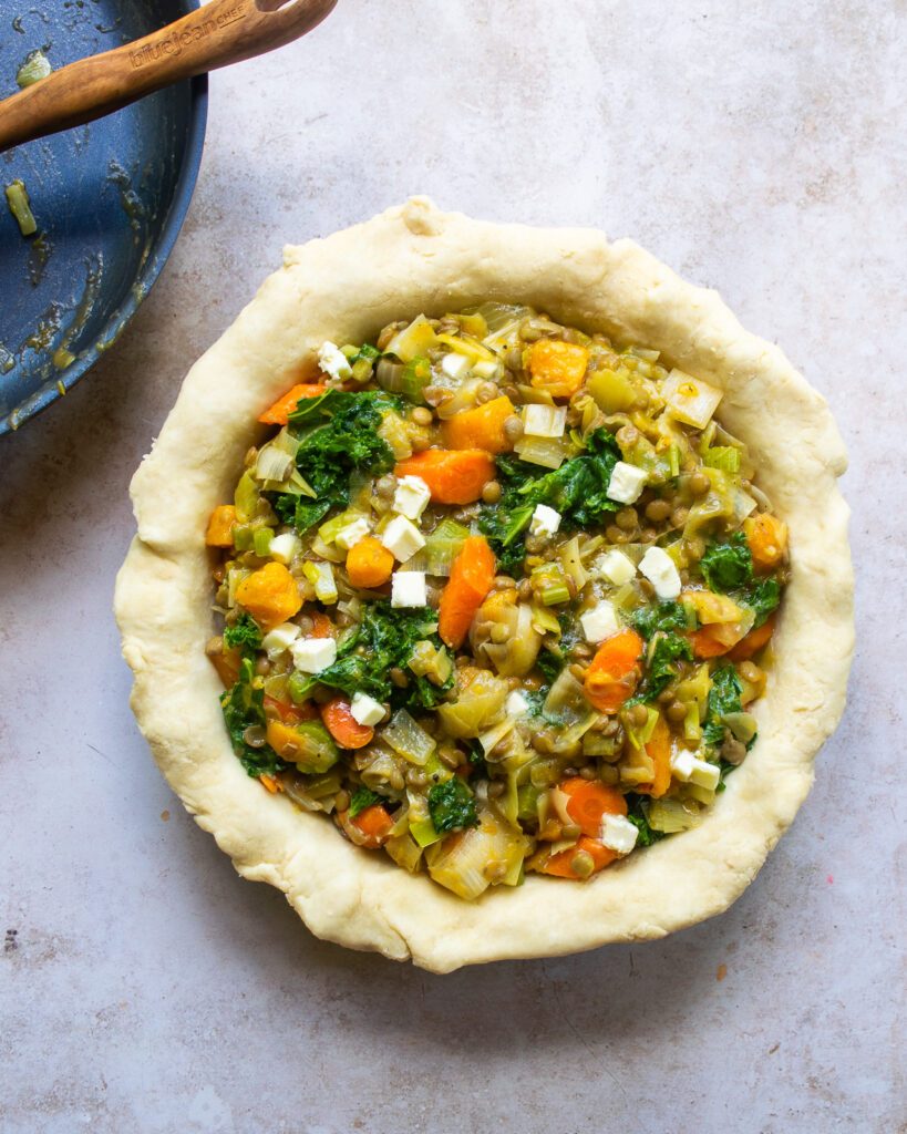 Looking down on a pie plate filled with pastry and vegetables.