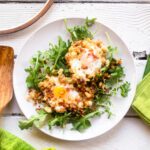 Looking down on a white plate with crispy eggs in breadcrumbs.